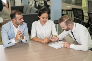 Pareja de emprendedores en sesión de consultoría de franquicias en España, formalizando la inversión con tarjeta de crédito.