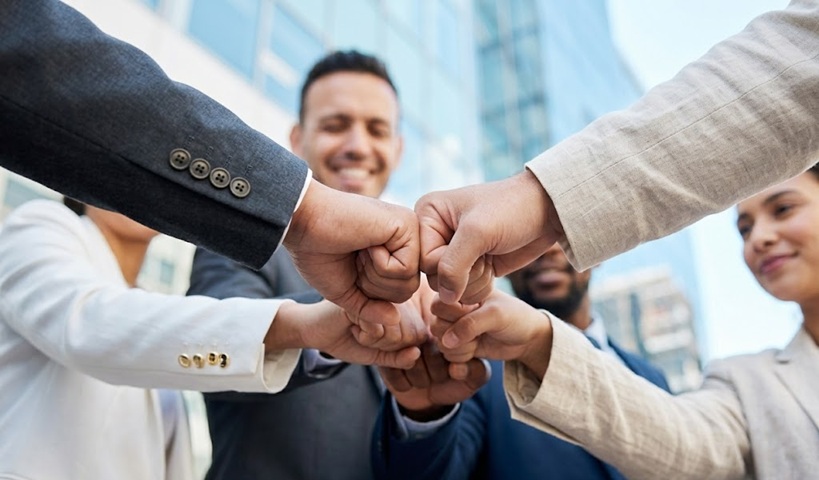 Equipo de socios cerrando un acuerdo de sinergias empresariales al comprar un negocio en España.