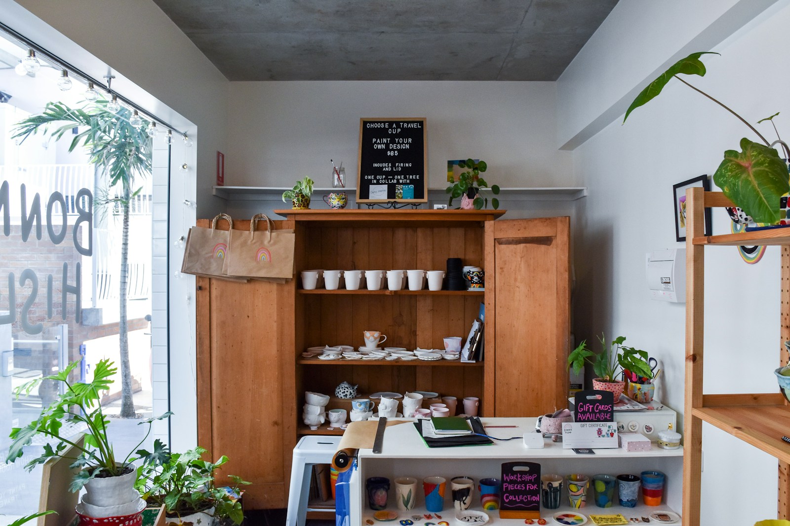 negocios pequeños rentables en España emprendedor sonriendo en su pequeño negocio cafeteria de especialidad en barrio español persona trabajando en marketing digital mapa de españa con zonas de inversion
