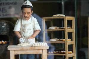 negocios pequeños rentables en España emprendedor sonriendo en su local cafeteria especialidad barrio grafico crecimiento negocio pequeño mapa de españa con oportunidades